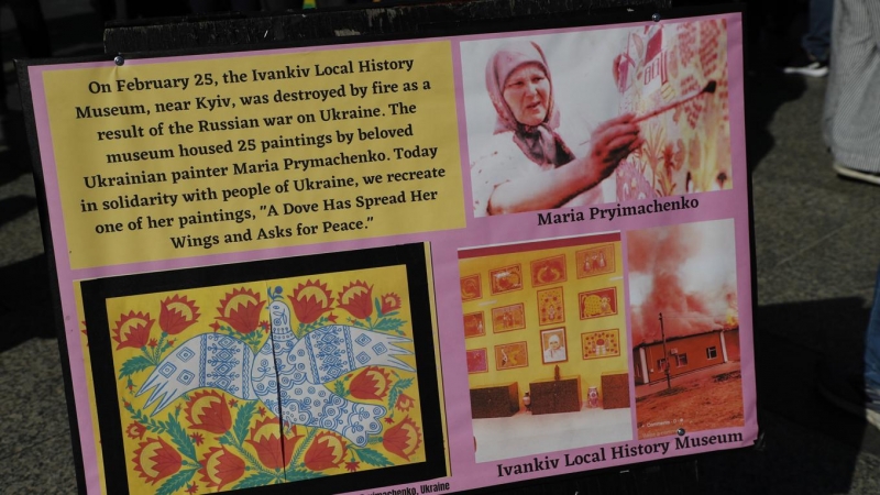 El artista y los ayudantes ayudan a recrear una obra de artista, 'Una paloma ha extendido sus alas y pide paz' de la amada pintora ucraniana Maria Prymachenko, quien tenía 25 pinturas que se encontraban en el Museo de Historia Local de Ivankiv, cerca de K