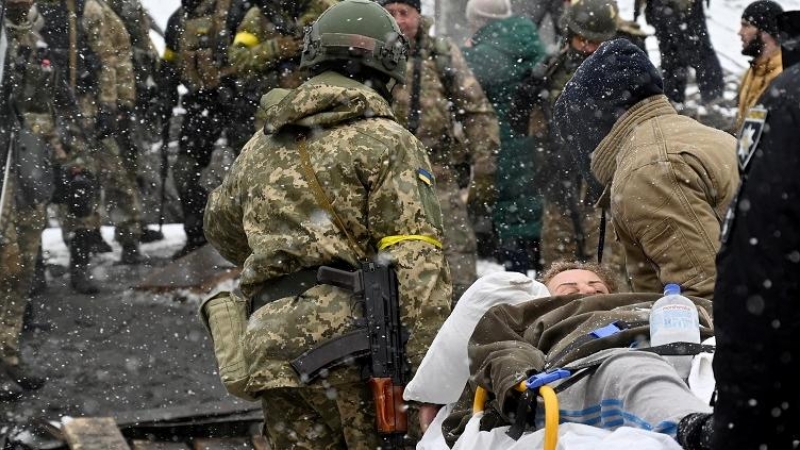 Un soldado ucraniano ayuda a una anciana a cruzar un puente destruido mientras evacua la ciudad de Irpin, al noroeste de Kiev, el 8 de marzo de 2022. Más de dos millones de personas han huido de Ucrania desde que Rusia lanzó su invasión a gran escala en m