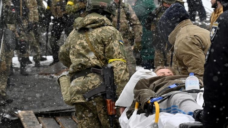 Un soldado ucraniano ayuda a una anciana a cruzar un puente destruido mientras evacua la ciudad de Irpin, al noroeste de Kiev, el 8 de marzo de 2022. Más de dos millones de personas han huido de Ucrania desde que Rusia lanzó su invasión a gran escala en m