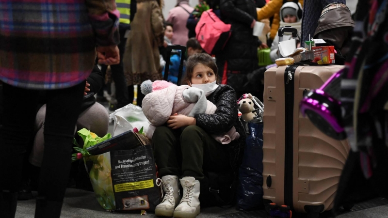 Niños con maletas sentados nada más llegar a la estación central de Berlín, este 8 de marzo de 2022, huyendo de la guerra de Ucrania.