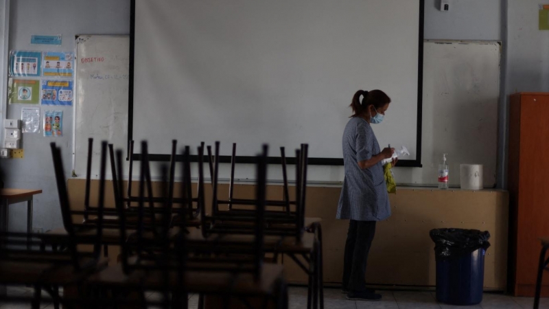 (28/02/2022) Una trabajadora marca un gel desinfectante en el aula de un colegio..
