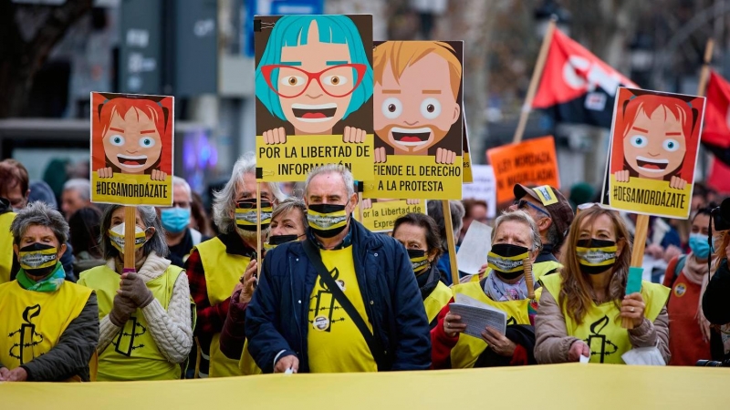 Varias personas con pancartas que rezan 'Por la libertad de información' participan en una manifestación contra la ley mordaza, a 13 de febrero de 2022, en Madrid (España).