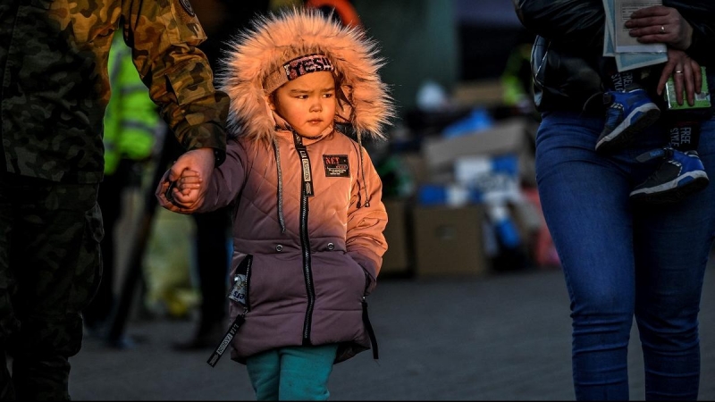 11/03/2022 Un militar ayuda a una niña después de que atravesara con su familia la frontera ucraniana con Polonia por Medyka