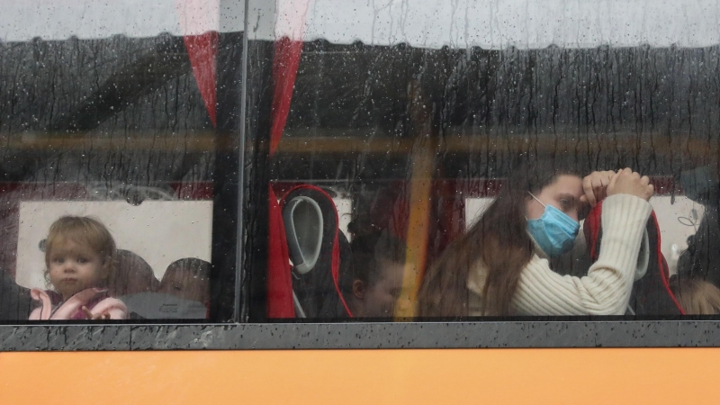 Varias personas, a bordo de un autobús, a su llegada a Madrid tras haber finalizado un viaje organizado por REMAR RUMANÍA para escapar de Ucrania, a 11 de marzo de 2022, en Ajalvir, Madrid