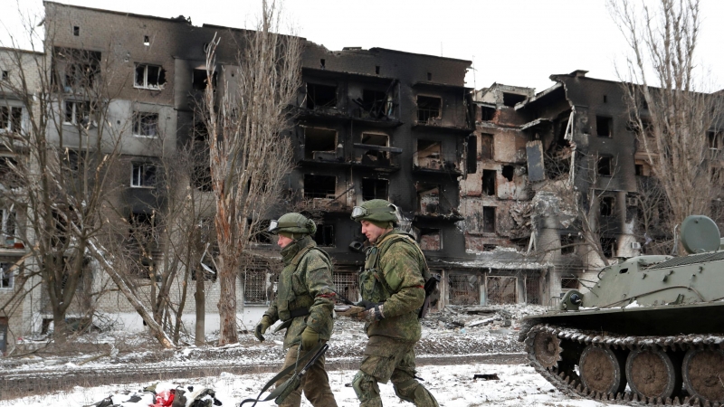 Los miembros del servicio de las tropas prorrusas caminan cerca de un edificio residencial que resultó gravemente dañado durante el conflicto entre Ucrania y Rusia en Volnovakha.
