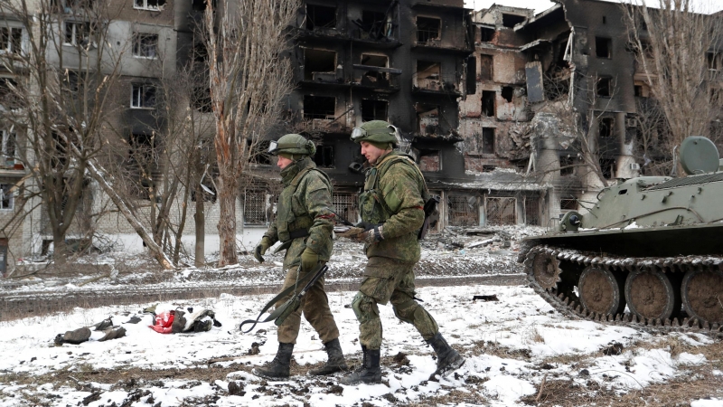 Los miembros del servicio de las tropas prorrusas caminan cerca de un edificio residencial que resultó gravemente dañado durante el conflicto entre Ucrania y Rusia en Volnovakha.