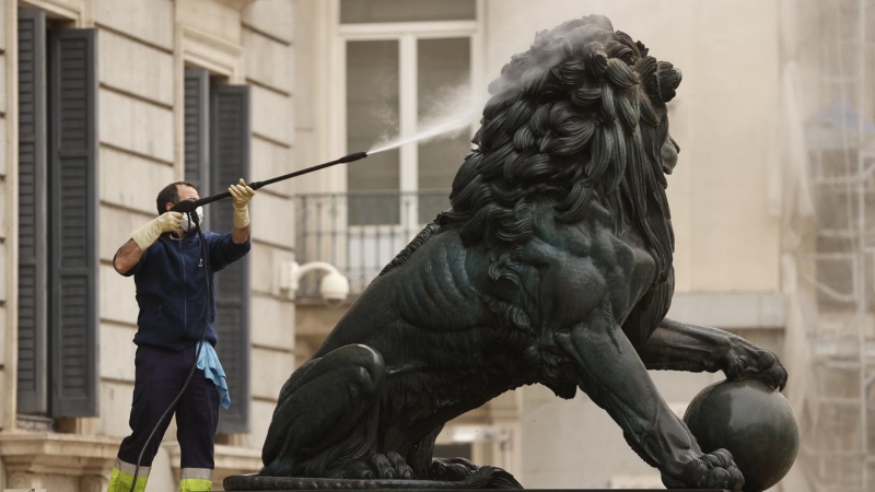 Un operario utiliza agua a presión para limpiar uno de los leones del Congreso, este martes.