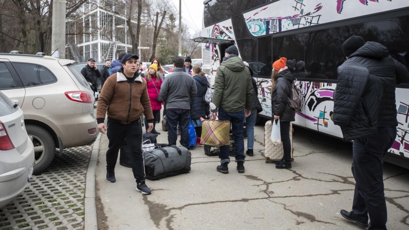 Ciudadanos ucranianos que huyen de Ucrania se preparan para tomar un autobús a Alemania.