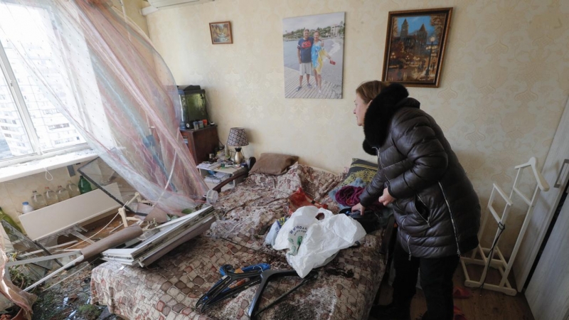 Una mujer recoge cosas en su apartamento de un edificio bombardeado en Kiev.