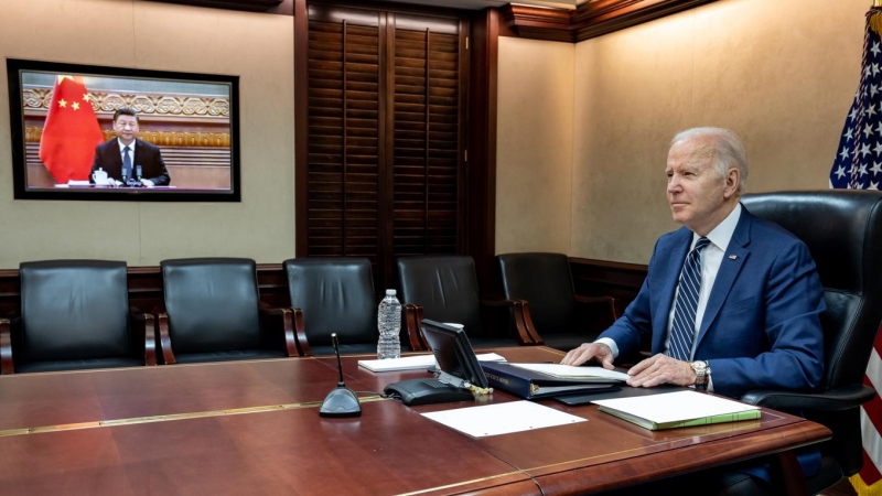 Fotografía cedida por la Casa Blanca donde aparece el presidente de Estados Unidos, Joe Biden (d), mientras habla con su homólogo chino, Xi Jinping (en pantalla), durante una reunión virtual hoy, desde su oficina en Washington (EEUU). Biden advirtió este