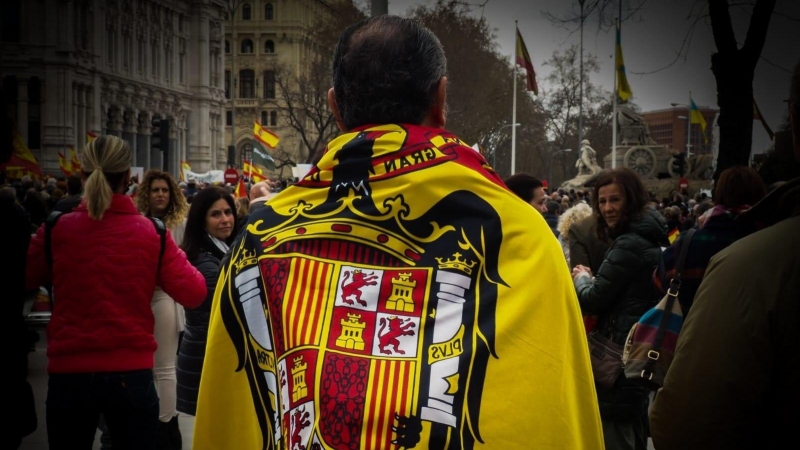 19/03/2022 Uno de los participantes de la manifestación convocada por Vox contra el Gobierno porta una bandera franquista