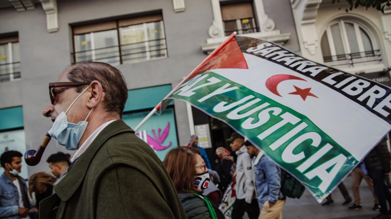 Un hombre sostiene una pancarta en una manifestación contra la violación de derechos en el Sáhara Occidental, a 13 de noviembre de 2021, en Madrid