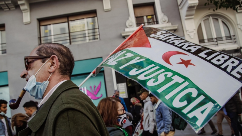 Un hombre sostiene una pancarta en una manifestación contra la violación de derechos en el Sáhara Occidental, a 13 de noviembre de 2021, en Madrid