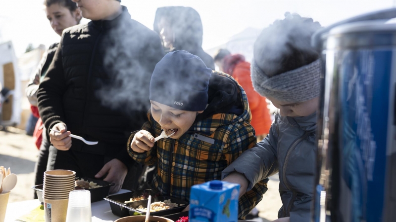Varios niños se alimentan este lunes en el campamento de refugiados en Budomierz (Polonia), en el paso fronterizo con Ucrania más cercano al bombardeo del IPSC de Yavoriv, a 25 kilómetros de la frontera polaca.
