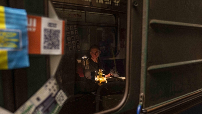 20/03/2022 Un hombre, a la luz de una pequeña lámpara en el metro de Járkov
