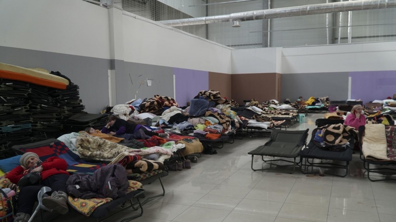 Refugiados ucranianos descansan sobre camas plegables en un centro comercial reconvertido en punto de acogida de refugiados ucranianos en la ciudad polaca de Korczowa, cerca de la frontera con Ucrania.