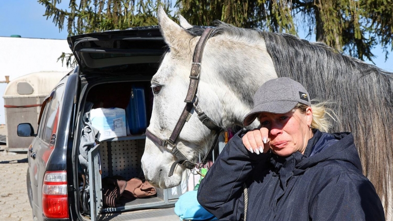 18/03/2022 Natalia Bordunova, refugiada ucraniana de 45 años procedente de Kiev, llora al lado de su caballo Utrerano en una granja en Kalnikow, Polonia