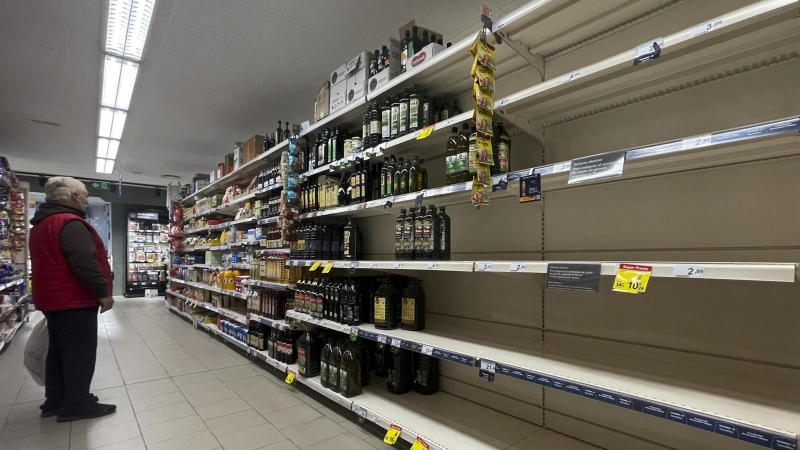 Un hombre observa unas estanterías vacías de aceite en un supermercado de Madrid este sábado 17 de marzo de 2022.