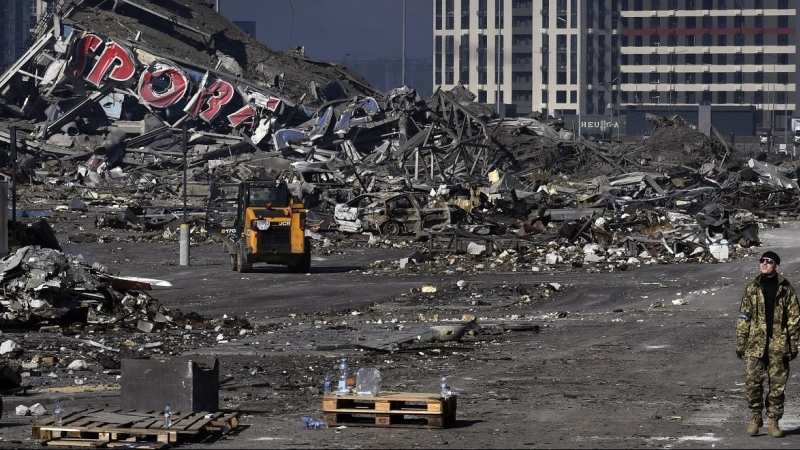 28/03/2022 Un soldado ucraniano camina junto a un centro comercial dañado en el distrito de Podilskyi tras un ataque con misiles rusos, que tuvo lugar el 23 de marzo de 2022.