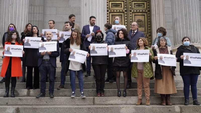 Varios diputados posan a las puertas del Congreso de los Diputados con carteles con fotos de Pablo González y la etiqueta #FreePablo este 30 de marzo de 2022.