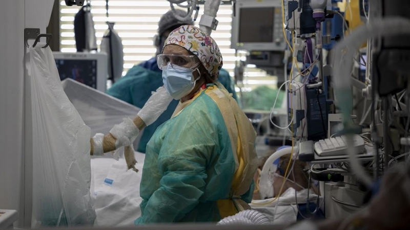 Dos sanitarios atienden a un paciente en la Unidad de Cuidados Intensivos (UCI) dedicada a enfermos de coronavirus del Hospital Universitario Ramón y Cajal, en Madrid (España), a 8 de octubre de 2020.
