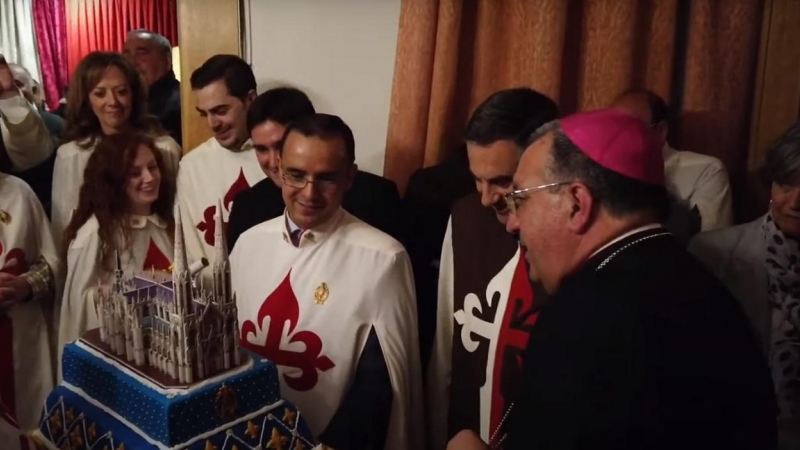 Miembros de la asociación Heraldos del Evangelio muestran al obispo de Getafe, Ginés García Beltrán, una tarta con una maqueta de la iglesia que proyectan construir en su 'macroproyecto' religioso en la localidad madrileña de Sevilla la Nueva. — Youtube