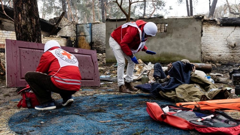 El personal de la Cruz Roja ayuda a un residente local mientras la organización humanitaria entrega alimentos y primeros auxilios a los residentes afectados por los combates durante la invasión rusa de Ucrania, en Irpin