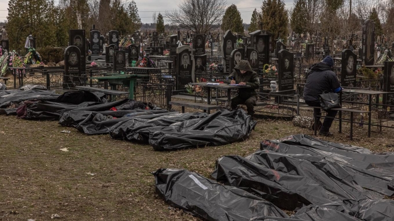 Oficiales de policía y personal forense verifican para identificar los cuerpos de las personas asesinadas, que fueron llevadas al cementerio en Bucha, al noroeste de Kiev, Ucrania, el 6 de abril de 2022.