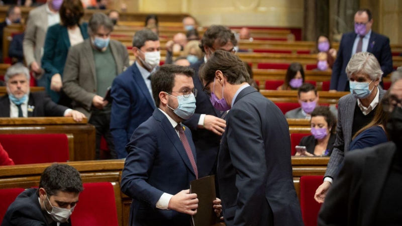El presidente de la Generalitat, Pere Aragonès, y el primer secretario del PSC, Salvador Illa, hablan durante una sesión plenaria en el Parlament de Catalunya, a 9 de marzo de 2022, en Barcelona.