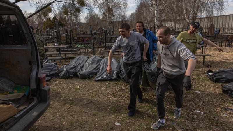 07/04/2022 Un grupo de voluntarios cargan en una furgoneta en el cementerio los cuerpos sin vida de los asesinados en Bucha