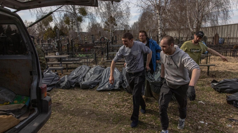 07/04/2022 Un grupo de voluntarios cargan en una furgoneta en el cementerio los cuerpos sin vida de los asesinados en Bucha