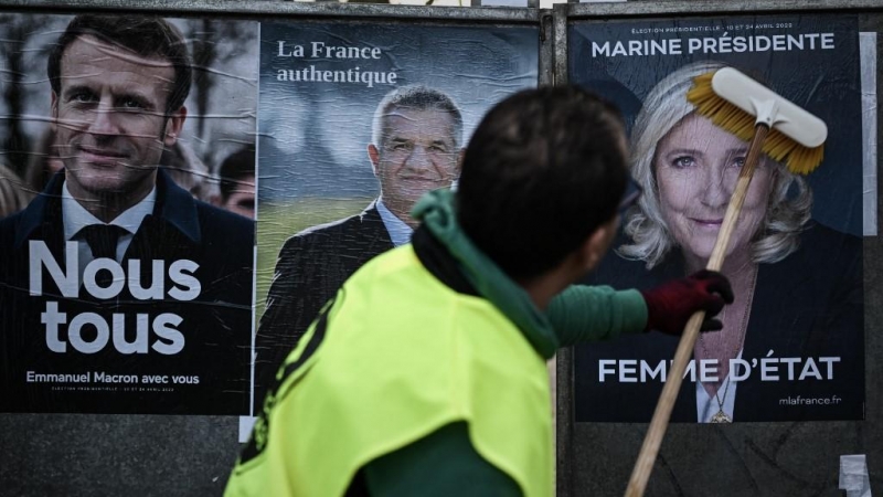 Un empleado de una empresa de exhibición coloca carteles de la campaña oficial de los candidatos presidenciales (desde la izquierda) ¡El presidente francés del partido centrista Emmanuel Macron La Republique en Marche (LREM), el agrarista francés Resiston
