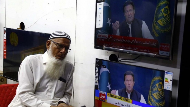 Un hombre junto a unas pantallas de televisión con la imagen del primer ministro paquistaní, Imran Jan, a 9 de abril de 2022.
