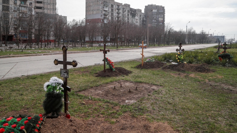 Las tumbas de los civiles muertos durante el conflicto entre Ucrania y Rusia se ven junto a edificios de apartamentos en la ciudad portuaria sureña de Mariupol , Ucrania, 10 de abril de 2022.