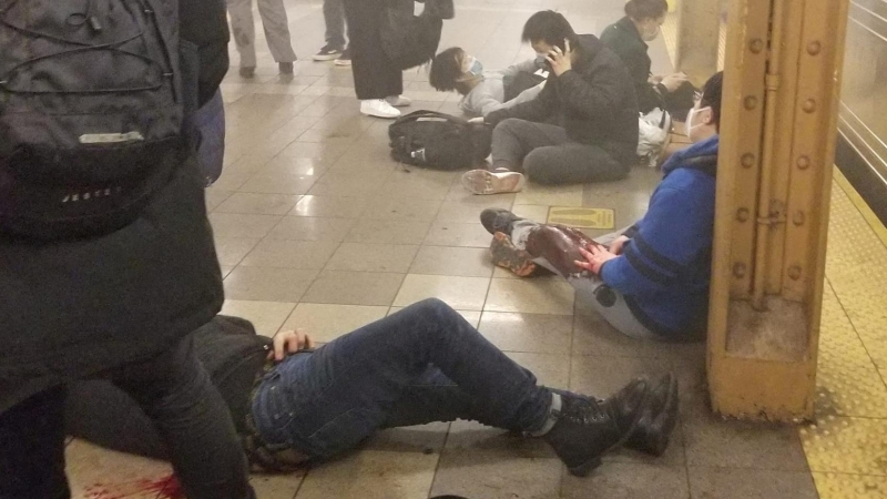 Personas heridas sentadas y tumbadas en el andén con manchas de sangre de la estación de metro de la calle 36 de Brooklyn, donde un hombre ha provocado un tiroteo este 12 de abril de 2022.