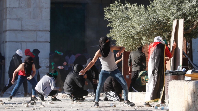 Los palestinos se enfrentan con la policía israelí dentro del complejo de la mezquita de Al-Aqsa después de que la policía israelí ingresara al complejo antes del amanecer mientras miles de musulmanes se reunían para rezar durante el mes sagrado del Ramad