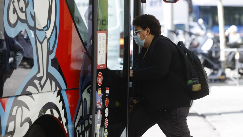 18/04/2022-Una mujer con mascarilla sube al autobús este lunes 18 de abril en Madrid