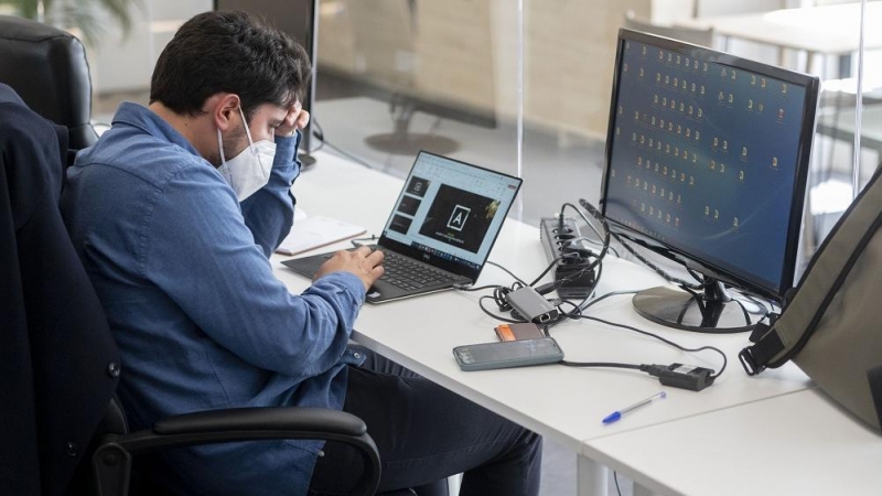 Un trabajador con mascarilla quirúrgica, el día en que ha entrado en vigor el decreto que pone fin al uso de la mascarilla en la mayoría de interiores, en la consultora de Marketing Alkemy, a 20 de abril de 2022, en Madrid (España).