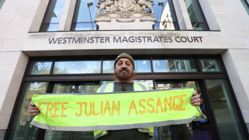 Un hombre sostiene una pancarta pidiendo la libertad de Assange durante una protesta frente al Tribunal de Magistrados de Westminster en Londres, este miércoles.