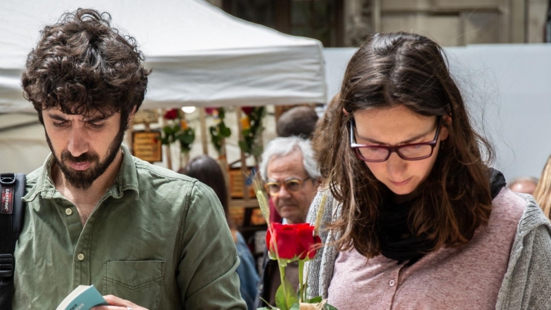 Dos personas miran libros en el día de Sant Jordi en Barcelona.