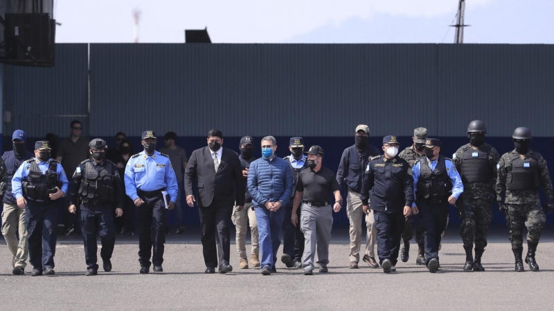 25/04/2022 - El expresidente hondureño Juan Orlando Hernández es dirigido al avión para su extradición a Estados Unidos, en la base aérea Hernán Acosta de Tegucigalpa.