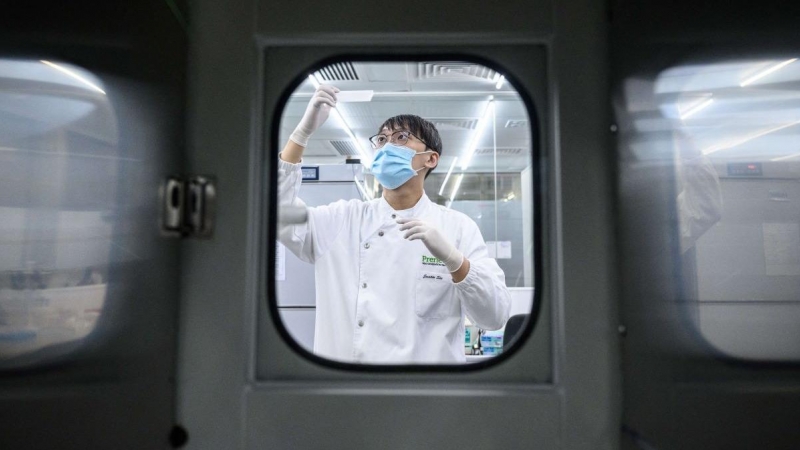 En esta foto tomada el 5 de junio de 2020, un empleado manipula una vacuna en un laboratorio de Hong Kong.