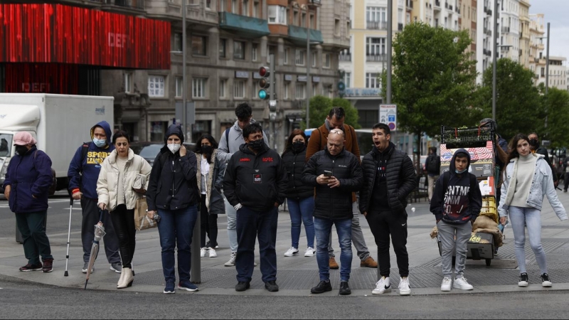 (20/4/2022) Varias personas esperan en un semáforo de la Gran Vía de Madrid el pasado miércoles, primer día sin la obligación de llevar mascarillas en interiores.