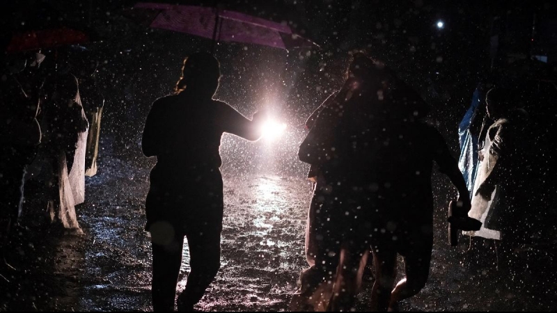 27/04/2022 Gente espera bajo la lluvia noticias de sus familiares detenidos durante el estado de emergencia, en los alrededores de la prisión de Izalco