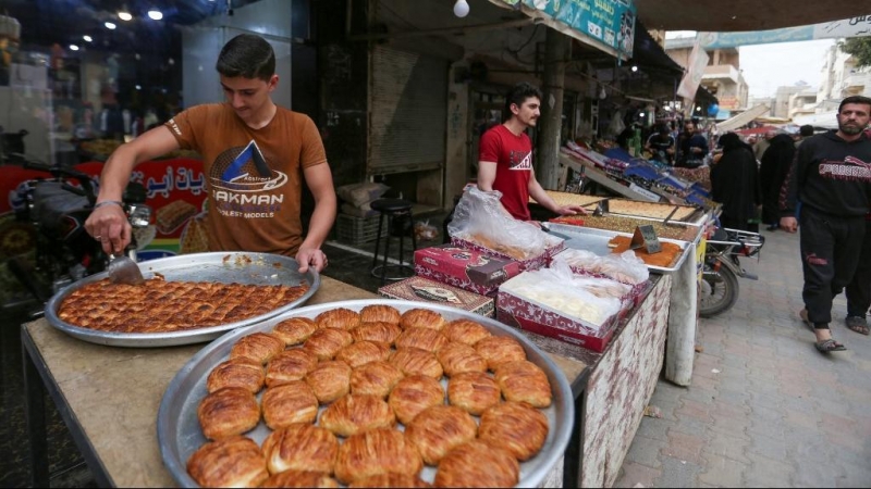 Los vendedores ambulantes sirios venden dulces de Eid en un mercado en la ciudad de Dana, en el noroeste del país, controlada por los rebeldes, mientras los musulmanes se preparan para celebrar Eid Al-Fitr, una festividad de tres días que marca el final d