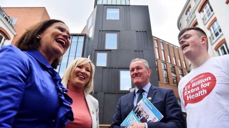 La presidenta de Sinn Fein, Mary Lou McDonald , y la vicepresidenta del partido, Michelle O'Neill, saludan a un partidario después del lanzamiento del Manifiesto de Sinn Fein para las próximas elecciones a la Asamblea de Irlanda del Norte, en Belfast, Irl