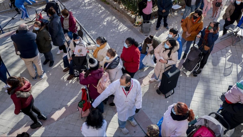 Varias personas hacen cola para recibir alimentos de la Fundación Madrina, en la plaza de San Amaro, a 7 de enero de 2022, en Madrid.