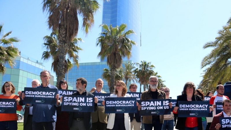 Diversos independentistes espiats per Pegasus en el 'Catalangate' mostren cartells contra l'espionatge davant de l'hotel Vela de Barcelona.