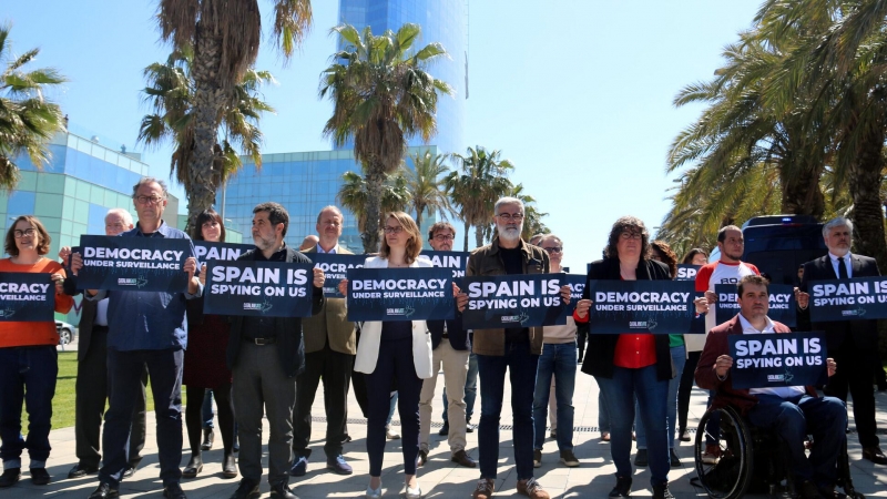 Diversos independentistes espiats per Pegasus en el 'Catalangate' mostren cartells contra l'espionatge davant de l'hotel Vela de Barcelona.