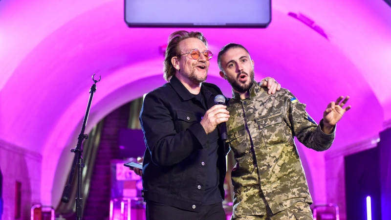 El músico irlandés Bono (i) de la banda U2 actúa con el cantante ucraniano Taras Topolya (d) de la banda Antytila, que ahora sirve en el ejército ucraniano, en la estación de metro de Khreshatyk en Kyiv (Kiev) este domingo, para apoyar a Ucrania en el con